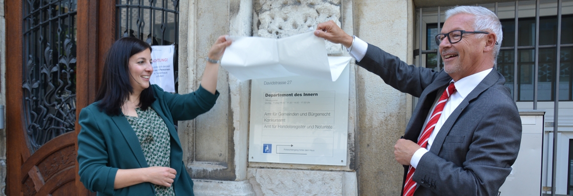 Martin Klöti und seine Nachfolgerin Laura Bucher enthüllen die Tafel des neuen Amtes für Gemeinden und Bürgerrecht